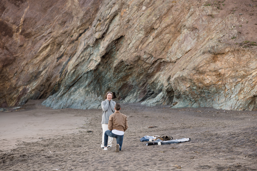 proposal on the beach by rocks